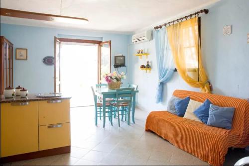 a living room with an orange couch and a table at 3 bedrooms apartement with sea view enclosed garden and wifi at Posada 2 km away from the beach in Posada