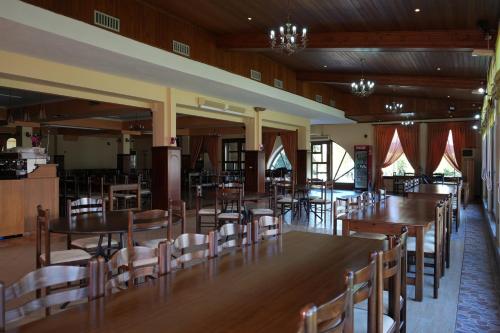 a dining room with wooden tables and chairs at HOTEL RESTORANT VIKTORIA in Gjirokastër