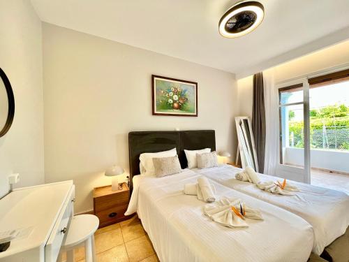 a bedroom with a large bed with white sheets at Beachfront Suites GardenMare by DadoVillas in Litherés