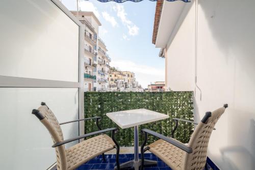 una mesa y sillas en un balcón con vistas en Brezza Marina, en Maiori