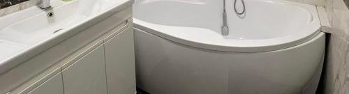 a white bathroom with a tub and a sink at Most City Area Pearl Apartment in Dnipro