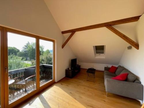 a living room with a couch and a large window at Aich22 in Peißenberg
