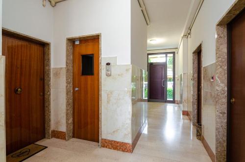 a hallway with wooden doors and tile floors at B&B Corsini in Bologna