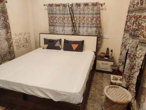 una camera da letto con letto, cuscini e tende di Six Seasons Celebrations a Calcutta