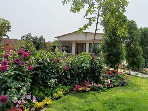 un giardino di fiori di fronte a una casa di Six Seasons Celebrations a Calcutta