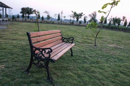 a park bench sitting in a field of grass at Six Seasons Celebrations in Kolkata