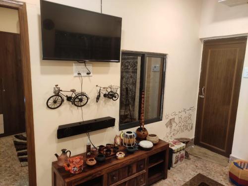 a living room with a television and two bikes on the wall at Six Seasons Celebrations in Kolkata