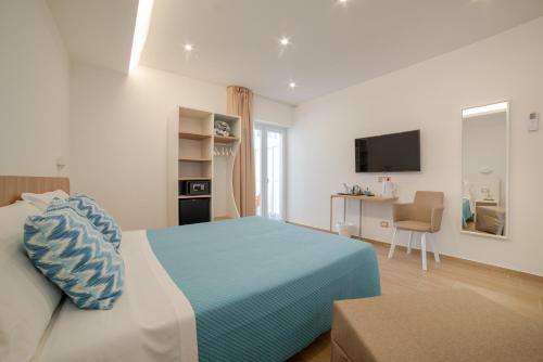 a bedroom with a bed and a desk and a television at Brezza Marina in Maiori