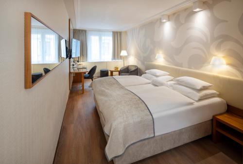 a hotel room with a large bed and a desk at Boutique Hotel Das Tigra in Vienna
