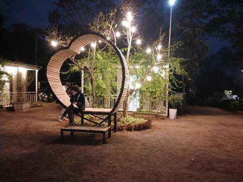 a couple sitting on a bench in a park at night at Halo Retreat in Hòa Bình