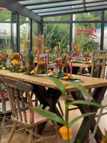 a long wooden table with candles on top of it at feels Beach Club Hotel in Kühlungsborn