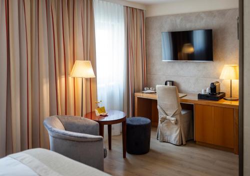 a hotel room with a bed and a desk with a chair at Boutique Hotel Das Tigra in Vienna