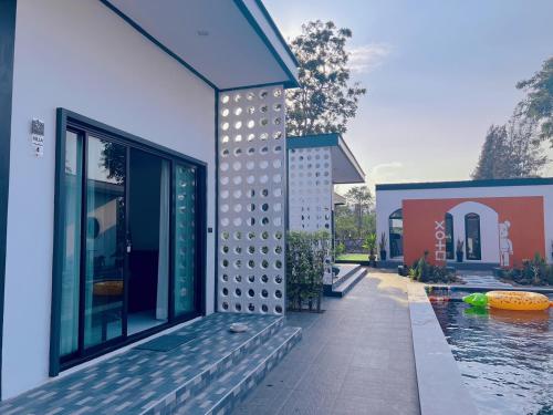 a house with a swimming pool next to a building at B.leaf in Ban Hup Kaphong