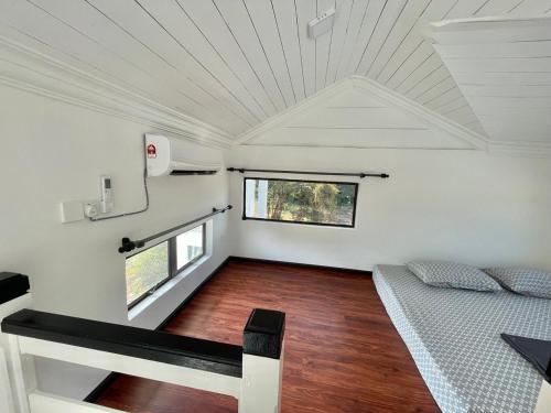 a small bedroom with a bed and a window at Memerang Tiny House & Pool 4 pax Merang in Setiu