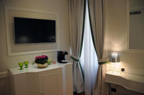 Cette chambre dispose d'une télévision et d'une table fleurie. dans l'établissement Suite Fontana di Trevi, à Rome