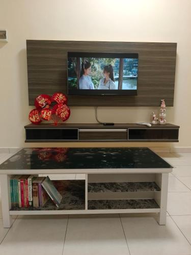 a living room with a tv on a wall at Homestay Sitiawan 53 in Sitiawan