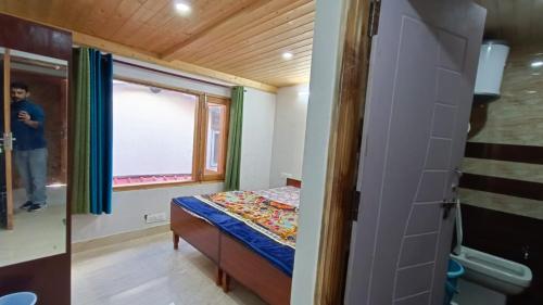 Habitación pequeña con cama y ventana en Shiv Shakti B & B, en Shimla