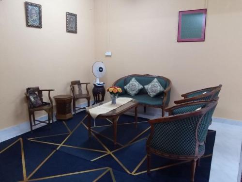 a living room with chairs and a table and a room with at CHE SUE HOMESTAY 02 in Pasir Mas