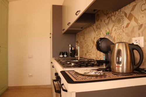 - une bouilloire installée au-dessus d'une cuisinière dans l'établissement Vista Panoramica a 5 minuti dal Lago Liscia, à Sant Antonio Di Gallura