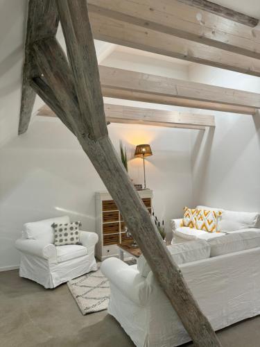 a living room with two white couches and a table at Sievershof Sieversloft in Wietzendorf