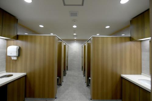 une rangée de stalles dans les toilettes publiques dans l'établissement Toyoko Inn Changwon, à Changwon