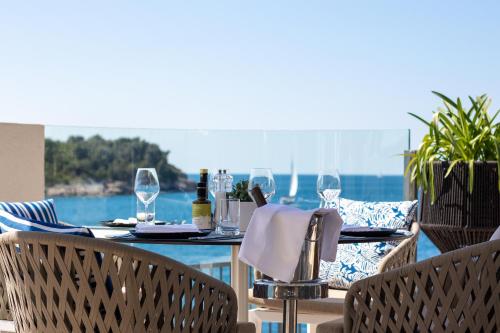 an outdoor table with wine glasses and a view of the ocean at Park Plaza Histria Pula in Pula