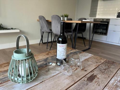 a bottle of wine sitting on top of a wooden table at Maisonette - Golf & Wellness in Oosterhout