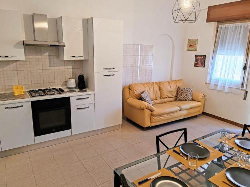 a kitchen and living room with a couch and a table at Trapani Emotions apartment in Valderice
