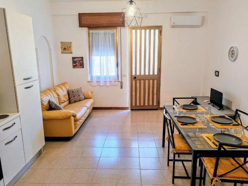 un soggiorno con tavolo e divano di Trapani Emotions apartment a Valderice