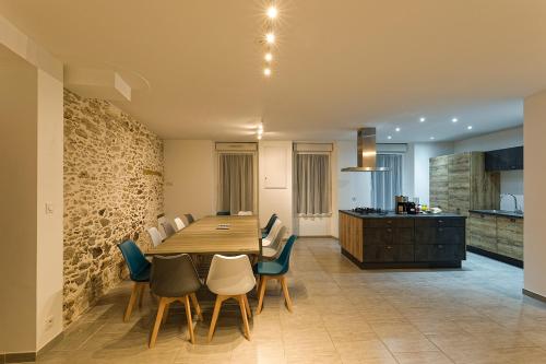 une cuisine et une salle à manger avec une table et des chaises en bois dans l'établissement Gîte Belle Entrée, à Saint-André-Goule-dʼOie