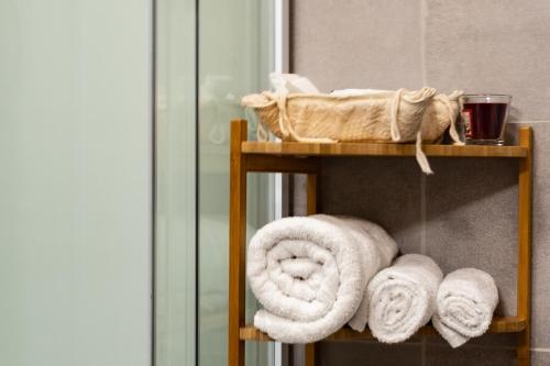 a towel rack with towels on it next to a mirror at Sa Burra Guest House in Gadoni