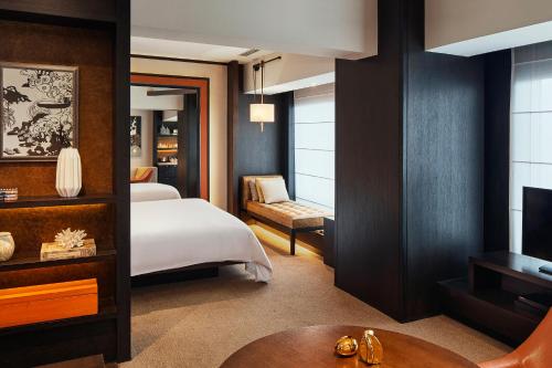 a hotel room with a bed and a television at Rosewood Beijing in Beijing