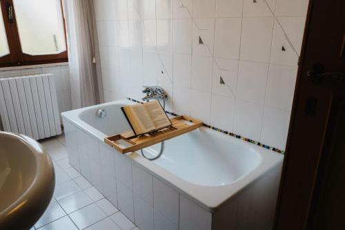 La salle de bains est pourvue d'une baignoire et d'un livre. dans l'établissement Casa Dalla Nita, à San Vito Rimini