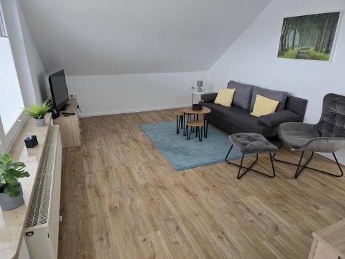 a living room with a couch and a tv at FerienApartment - FeWo Weitblick in Sassenburg