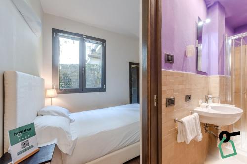 una piccola camera con letto e lavandino di HOTIDAY ApartHotel Firenze a Firenze