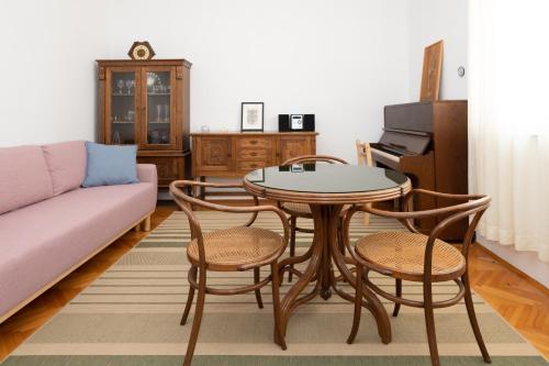 - un salon avec une table, des chaises et un canapé dans l'établissement Piano Apartment, à Šibenik