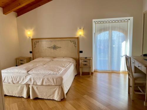 una camera con letto, scrivania e finestra di Relais Fontana Rosa B&B Wellness a Caprino Veronese