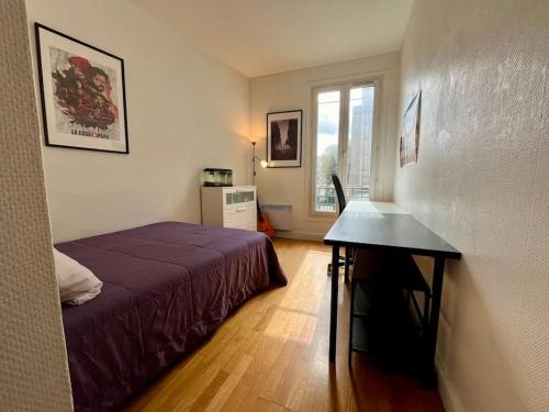 - une chambre avec un lit et un bureau dans l'établissement Bienvenue, à Montrouge