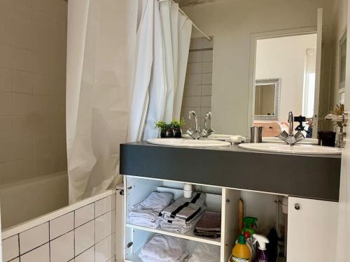 La salle de bains est pourvue de 2 lavabos et d'un miroir. dans l'établissement Bienvenue, à Montrouge