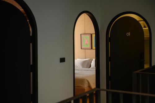 a bedroom with a bed and two arched doors at Stupid Stay in Bangkok