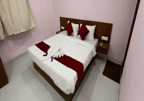a bedroom with a bed with red and white pillows at Hotel Kharadi Inn in Pune