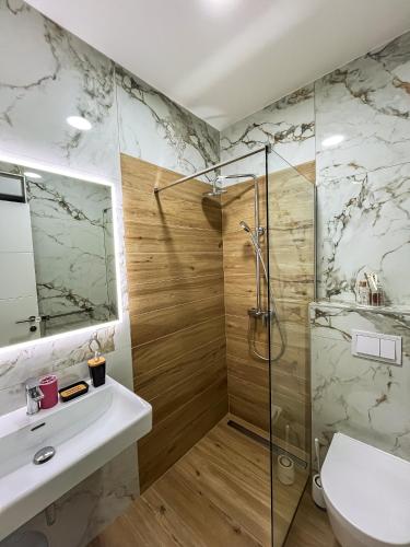 a bathroom with a shower and a sink and a toilet at Vila Biser Vodice in Vodice