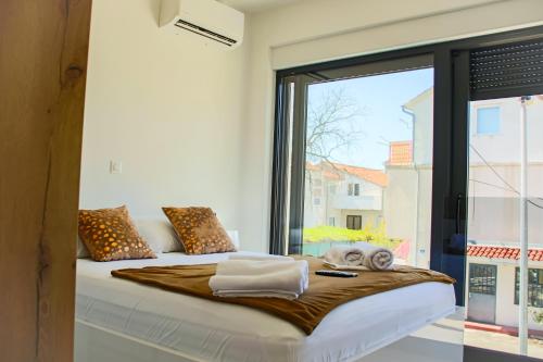 una camera da letto con un letto con una grande finestra di Vila Biser Vodice a Vodice