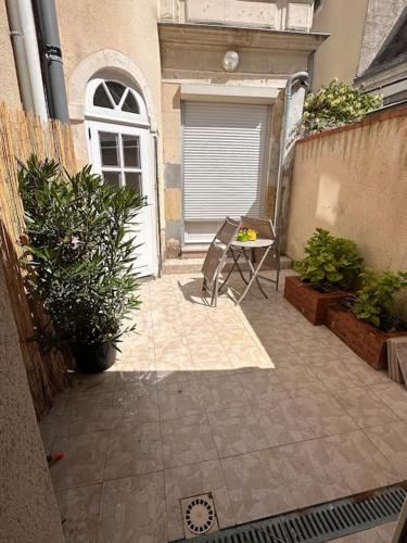 a patio with a table and some plants at Appartement cœur de ville in La Flèche