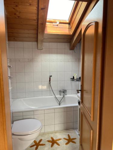 La salle de bains est pourvue de toilettes, d'une baignoire et d'un lavabo. dans l'établissement Gemütliche Dachgeschosswohnung mit Balkon, à Ainring