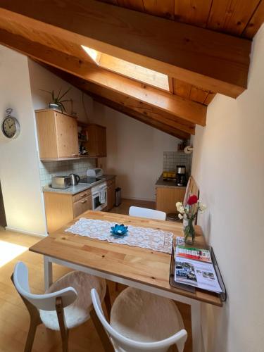 a kitchen with a wooden table and two chairs at Gemütliche Dachgeschosswohnung mit Balkon in Ainring