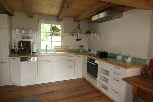 a kitchen with white cabinets and a window at Haus Nr. 9 in Ruppichteroth