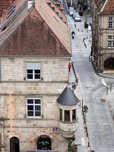 an old building with a clock tower on a street at Aurel's & Jul's Location-Luxeuil Meublés pour Professionnels Curistes et Touristes in Luxeuil-les-Bains