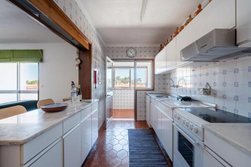 a kitchen with white cabinets and a counter top at GuestReady - Pleasant Retreat in Moledo in Moledo