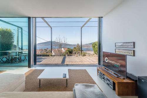 GuestReady - Lugar do Monte Seixas في كامينيا: غرفة معيشة مع أريكة ونافذة كبيرة